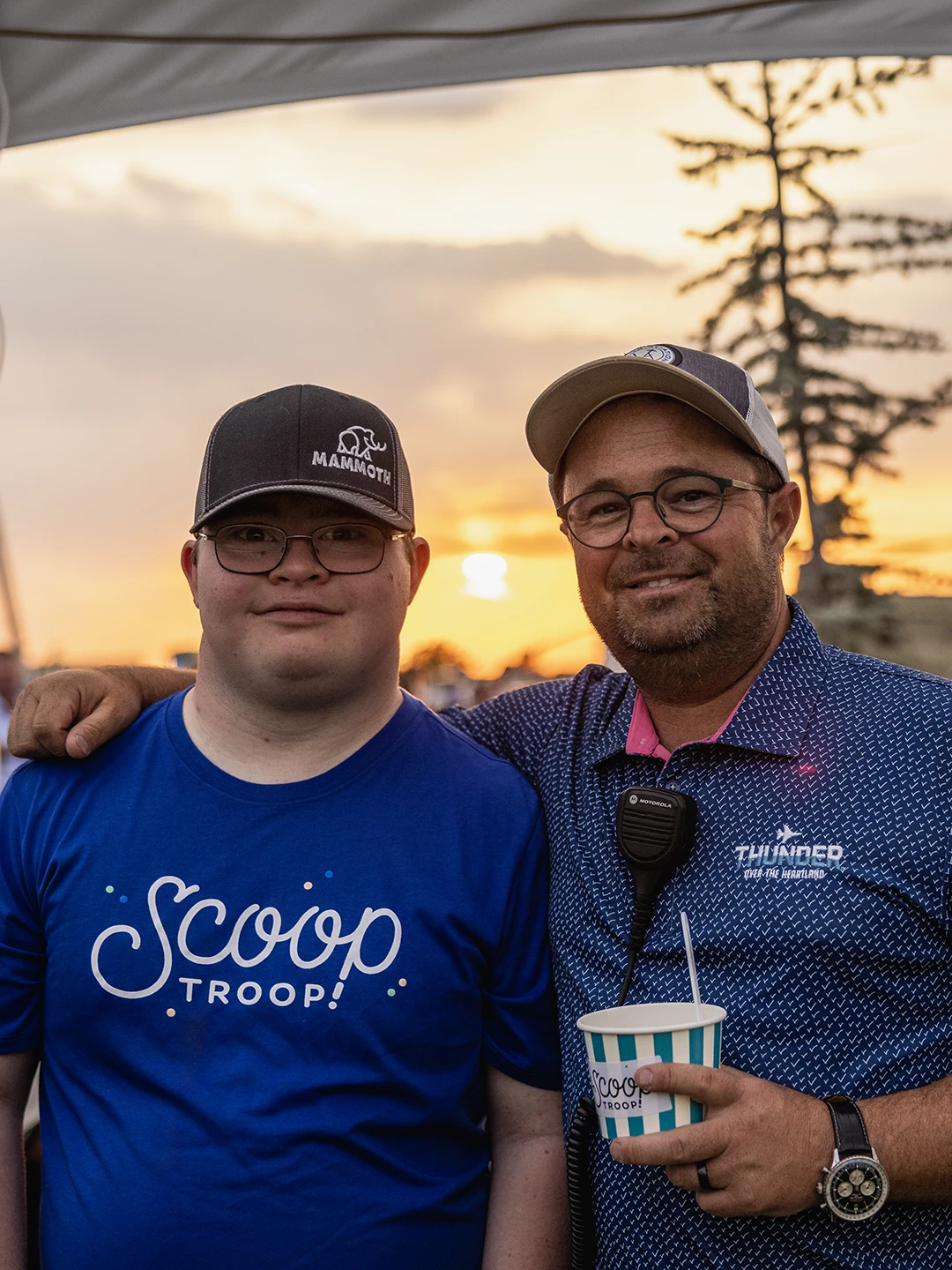 young man in a scoop troop t-shirt standing with an older man