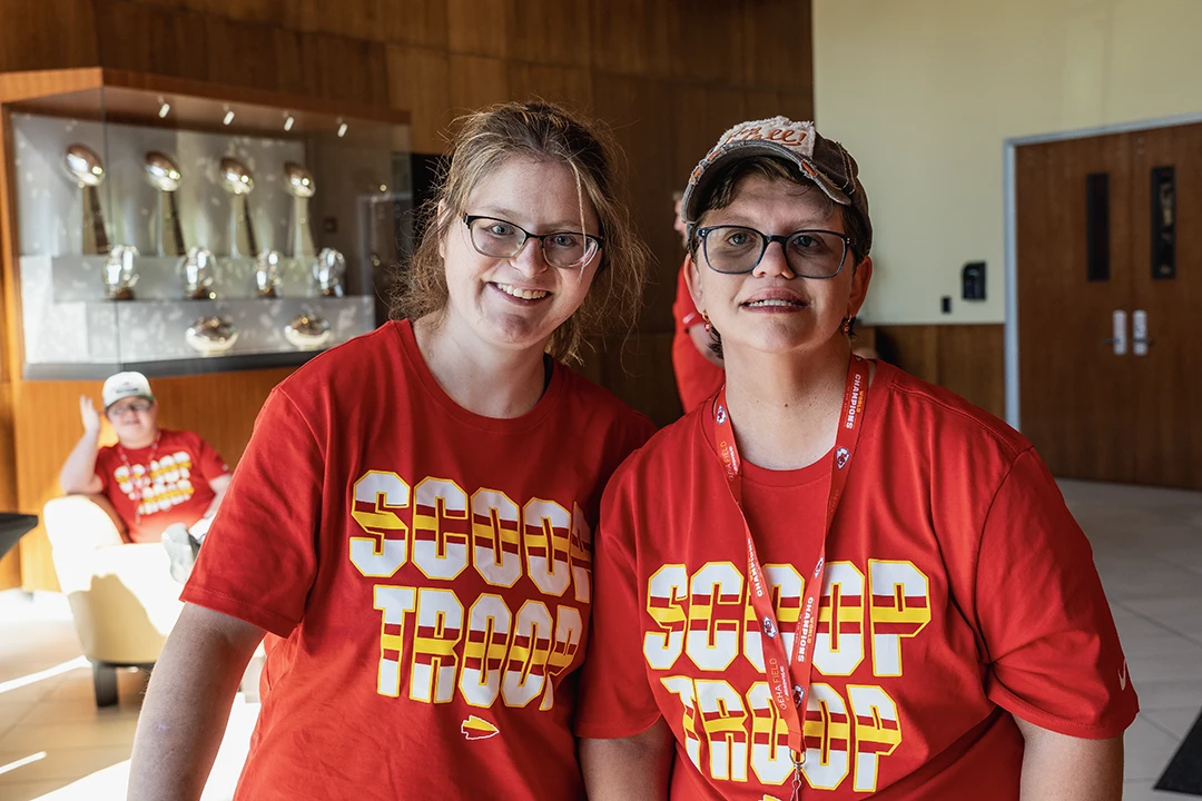 two female scoop troop employees posing together for the camera