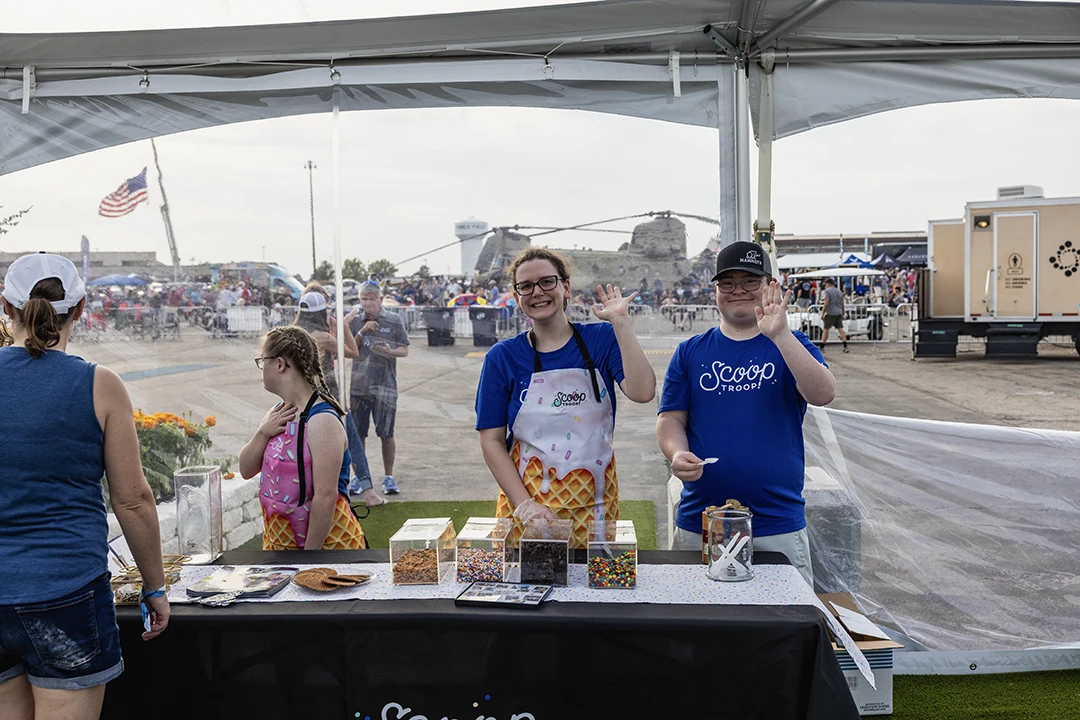 scoop troop employees waiving at the camera
