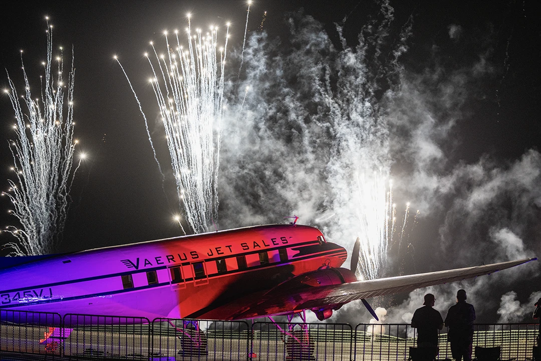 airplane with fireworks behind it